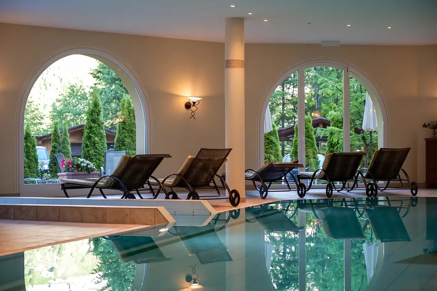 Liegen am Hallenbad vor Bogenfenstern zum Wald