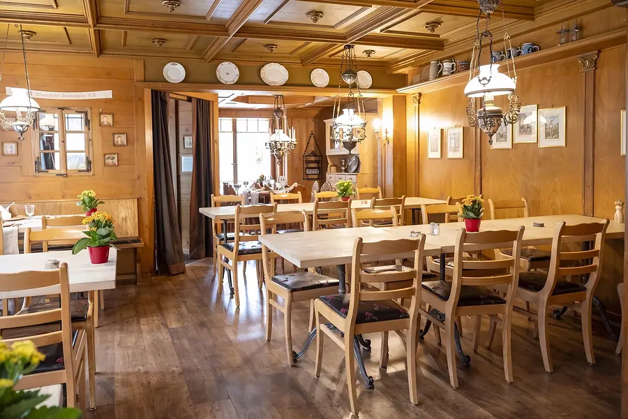 Burestube mit Holztäfer und langen Tischen