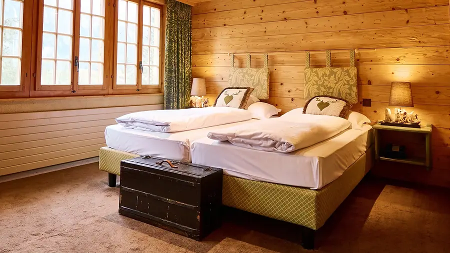 Economy-Zimmer mit zwei Betten und alter Truhe