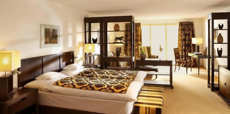 Zimmer mit Bett und Sitzecke im Abendlicht
